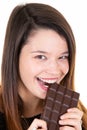 Portrait of young woman holding eating chocolate bar looks in camera Royalty Free Stock Photo