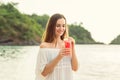 Portrait of a young woman holding a fresh watermelon cocktail on tropical beach