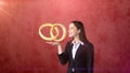 Portrait of young woman holding golden wedding rings on the open hand palm, isolated studio background. Business concept Royalty Free Stock Photo