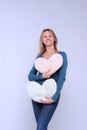 Portrait Of A Young Woman Holding A Heart Shaped Pillows. Young Girl Have A Fun.
