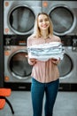 Woman with ironed clothes in the laundry