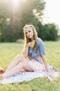 Portrait of a young woman holding orange juice in a glass in an open park Royalty Free Stock Photo