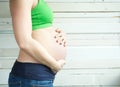 Portrait of a young woman holding pregnant belly Royalty Free Stock Photo