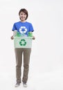 Portrait of young woman holding recycling bin, studio shot Royalty Free Stock Photo