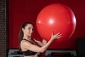 Portrait of a young woman holding a Swiss ball exercise and smiling at the camera. Live female fitness model image Royalty Free Stock Photo