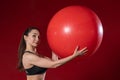 Portrait of a young woman holding a Swiss ball exercise and smiling at the camera. Live female fitness model image Royalty Free Stock Photo