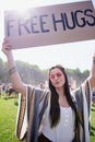 Boho woman holding up free hug sign at festival Royalty Free Stock Photo