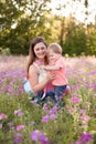 Portrait of young woman hugging her little toddler son on a sunny meadow. Royalty Free Stock Photo