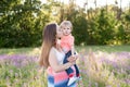 Portrait of young woman hugging her little toddler son on a sunny meadow. Royalty Free Stock Photo