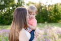 Portrait of young woman hugging her little toddler son on a sunny meadow. Royalty Free Stock Photo