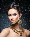 Portrait of a young woman in jewelry on snow