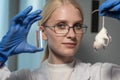 Portrait of a young woman laboratory assistant in glasses for vision with a mouse and a glass ampoule. Testing a new