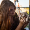 Portrait of a young woman with long red hair playing with a two month old cream colored kitten Royalty Free Stock Photo