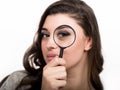 Portrait of young woman looking through magnifying glass Royalty Free Stock Photo