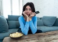 Portrait of a young woman looking scared and shocked watching TV. Human expressions and emotions Royalty Free Stock Photo