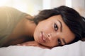 Time is precious, waste it wisely. Portrait of a young woman lying on her bed. Royalty Free Stock Photo