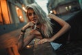 Portrait of young woman lying on wet pavement on city street in