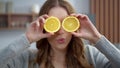 Young woman holding two orange slices at kitchen. Girl making faces with oranges Royalty Free Stock Photo