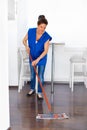 Portrait Of Young Woman Mopping Floor At Home . Cleaning Sevice