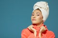 Portrait of young woman during morning procedures. Charming teen girl with towel on her head wearing bathrobe Royalty Free Stock Photo