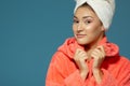 Portrait of young woman during morning procedures. Charming teen girl with towel on her head wearing bathrobe Royalty Free Stock Photo