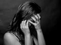 Portrait of young woman, no make up, low key, brown dark hair, no retouch making expressions