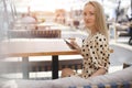 Portrait of a young woman outdoor in cafe with mobile phone Royalty Free Stock Photo