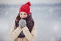 Portrait of a young woman outdoors under snovfall.