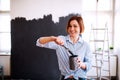 A portrait of young woman painting wall black. A startup of small business. Royalty Free Stock Photo