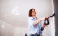 A portrait of young woman painting wall black. A startup of small business. Royalty Free Stock Photo