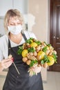 Portrait of a young woman picking a beautiful fruit bouquet of nuts, lemons and mint Royalty Free Stock Photo