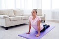 Portrait of young woman practicing yoga at home indoor, copy space. Girl practicing cobra pose, full length. Royalty Free Stock Photo