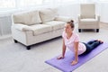 Portrait of young woman practicing yoga at home indoor, copy space. Girl practicing cobra pose, full length. Royalty Free Stock Photo