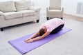 Portrait of young woman practicing yoga at home indoor, copy space. Girl relax meditation in child`s pose, full length. Royalty Free Stock Photo