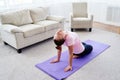 Portrait of young woman practicing yoga at home indoor, copy space. Girl stretching on mat, full length. Relaxing and doing yoga. Royalty Free Stock Photo