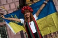 Portrait of young woman protesting against the war with an ukrainian flag in the street