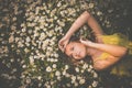 Portrait of young woman with radiant clean skin lying down amid flowers on a lovely meadow Royalty Free Stock Photo