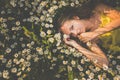 Portrait of young woman with radiant clean skin lying down amid flowers on a lovely meadow Royalty Free Stock Photo