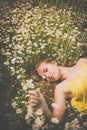 Portrait of young  woman with radiant clean skin lying down amid flowers on a lovely meadow Royalty Free Stock Photo