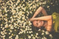 Portrait of young  woman with radiant clean skin lying down amid flowers Royalty Free Stock Photo