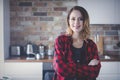 Portrait of young woman in red shirt at kitchen Royalty Free Stock Photo