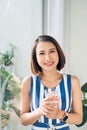 Portrait of young woman relaxing near the door and holding a cup of coffee/tea Royalty Free Stock Photo