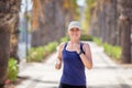 Portrait of young woman running on the palm alley