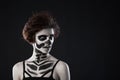 Portrait of young woman with scared halloween makeup on black background