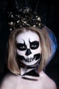 Portrait of young woman with scared halloween makeup over black background