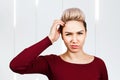 Portrait of young woman scratching head, thinking, looking aside Royalty Free Stock Photo