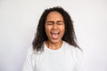 Portrait of young woman screaming with closed eyes