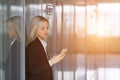 Portrait of young woman sending message on smartphone in office. Copy space. Royalty Free Stock Photo