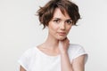 Portrait of young woman with short brown hair in basic t-shirt looking at camera Royalty Free Stock Photo