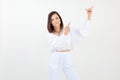 Portrait of young woman standing, raising hands, pointing with index fingers, looking at camera on white background. Royalty Free Stock Photo